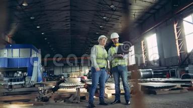 专业重工工程师.. 两个工人在一家建材厂谈话